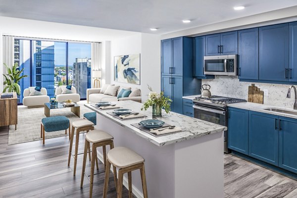 Modern kitchen with stainless steel appliances and quartz countertops in Fallyn Apartments