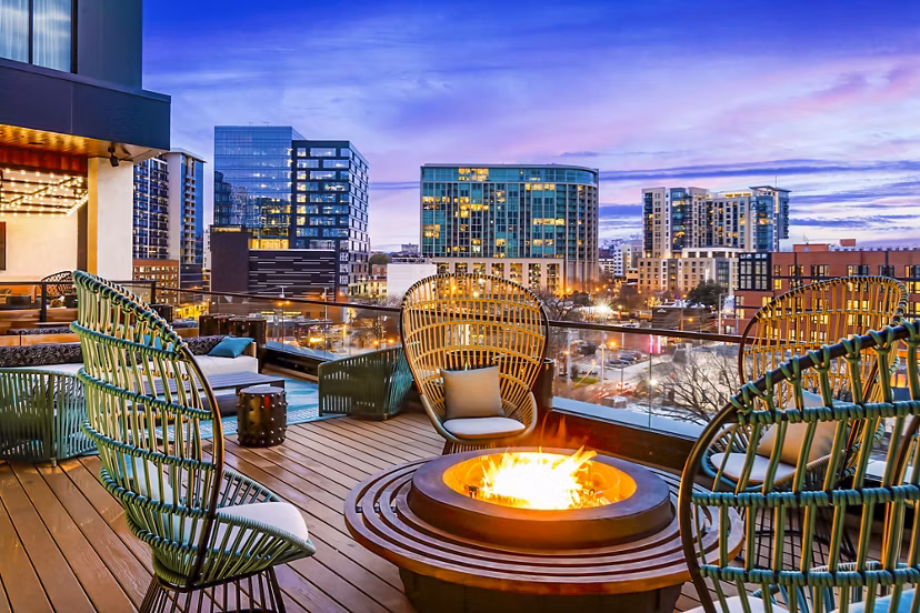 Outdoor fire pit and seating area on balcony at Fallyn Apartments offering a cozy outdoor experience