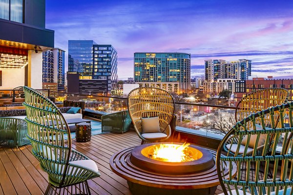 Outdoor fire pit and seating area on balcony at Fallyn Apartments offering a cozy outdoor experience
