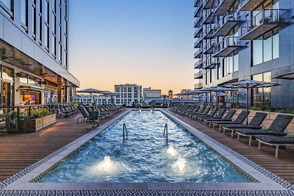 Crystal-clear pool at Fallyn Apartments, a luxury Greystar property with relaxing lounge areas and lush landscaping