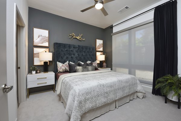 Bedroom featuring contemporary design and plush bedding at The Flats at West Alabama Apartments