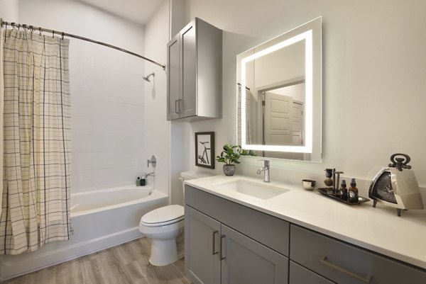 The Flats at West Alabama Apartments: Modern bathroom with sleek finishes and ample lighting
