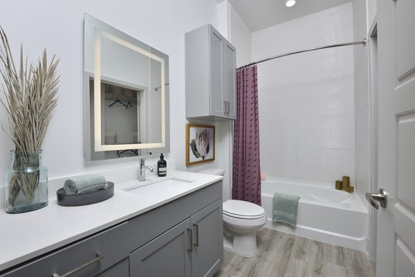 Bathroom featuring sleek marble countertops and modern fixtures at The Flats at West Alabama Apartments, Greystar luxury property in Houston