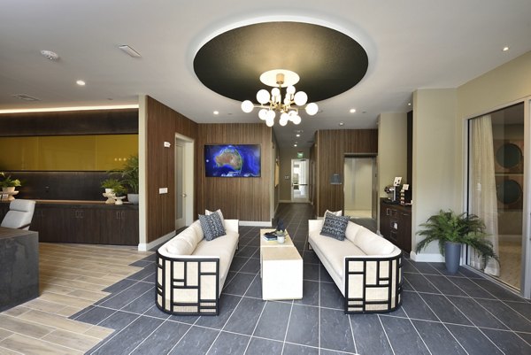 Clubhouse featuring modern decor and communal seating at The Flats at West Alabama Apartments
