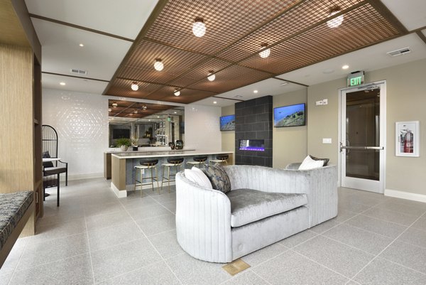Clubhouse interior featuring modern design and seating areas at The Flats at West Alabama Apartments