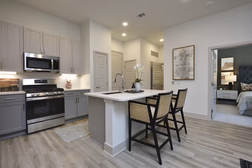 Modern kitchen with sleek countertops and stainless steel appliances at The Flats at West Alabama Apartments