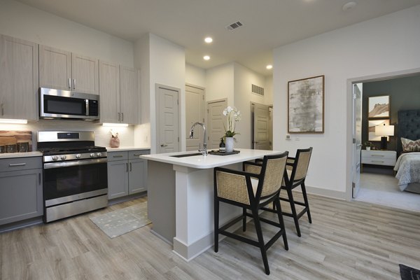 Modern kitchen with sleek countertops and stainless steel appliances at The Flats at West Alabama Apartments