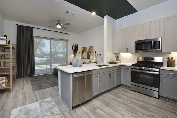 Modern kitchen with stainless steel appliances at The Flats at West Alabama Apartments