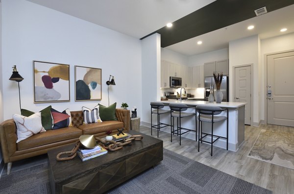 Spacious living room with sleek modern furniture at The Flats at West Alabama Apartments