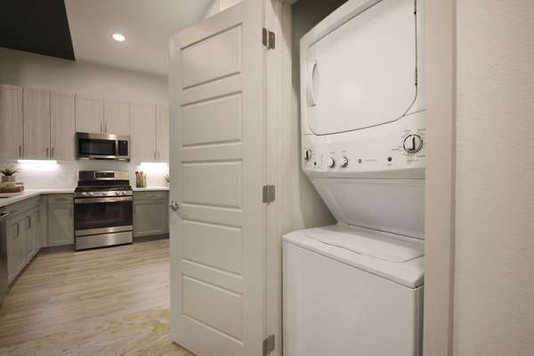 Spacious laundry room with modern appliances in The Flats at West Alabama Apartments