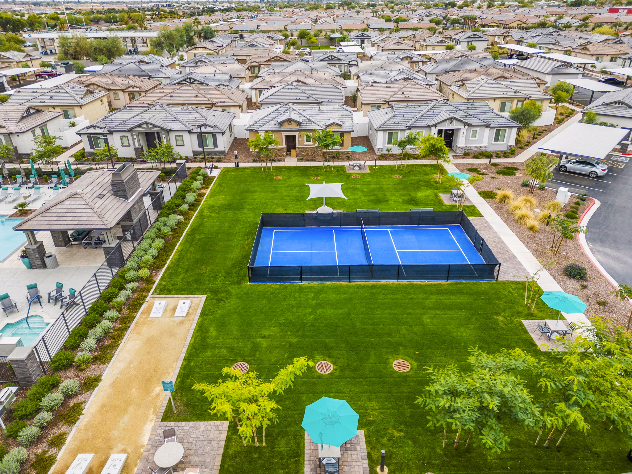 Outdoor tennis court at Vlux at Peoria Heights Apartments, featuring well-maintained playing surface and lighting for evening matches