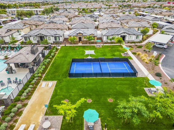 Outdoor tennis court at Vlux at Peoria Heights Apartments, featuring well-maintained playing surface and lighting for evening matches