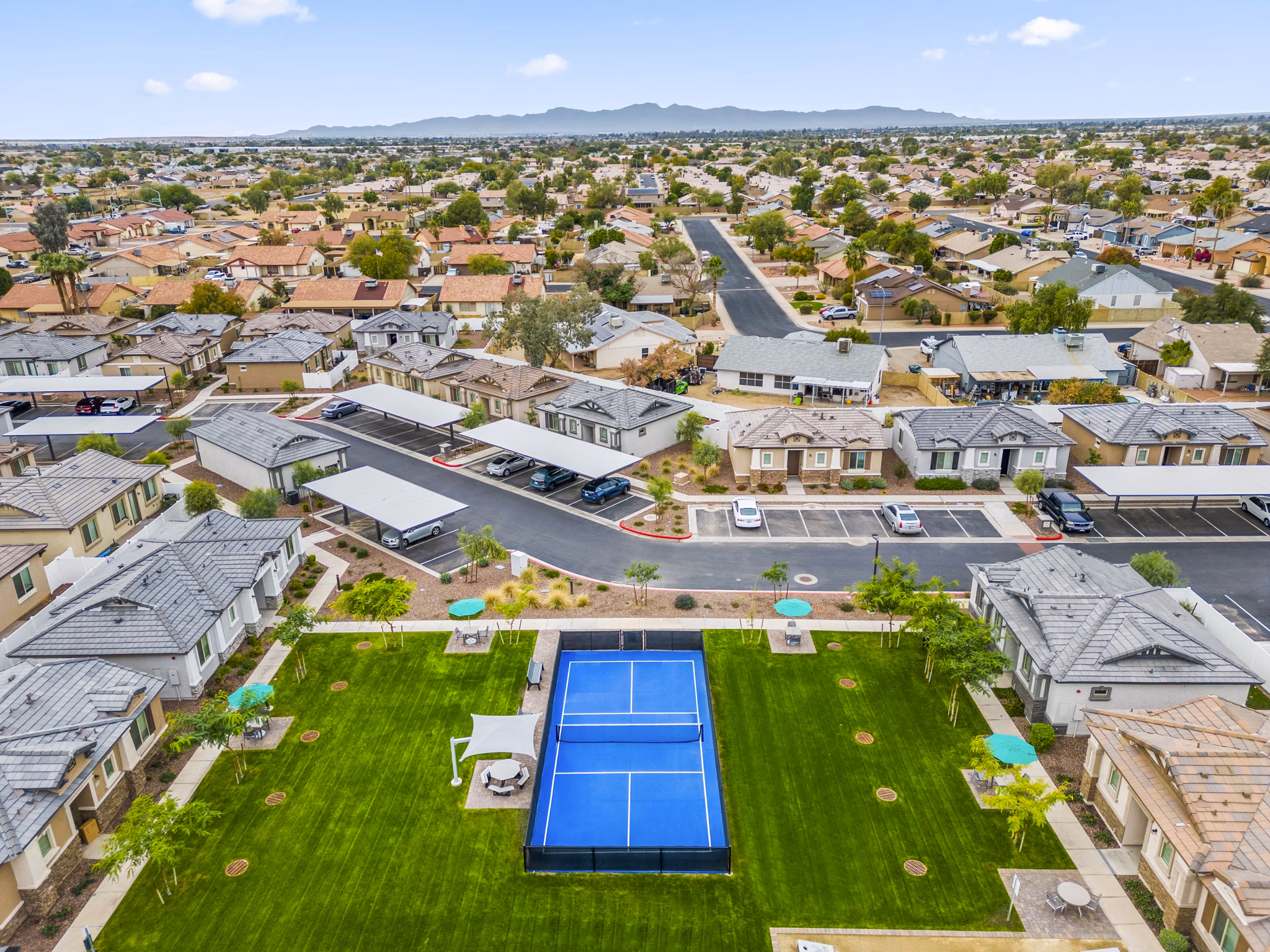Tennis court with lush surroundings at Vlux at Peoria Heights Apartments