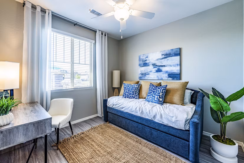 Contemporary bedroom with home office space at Vlux at Queen Creek Apartments