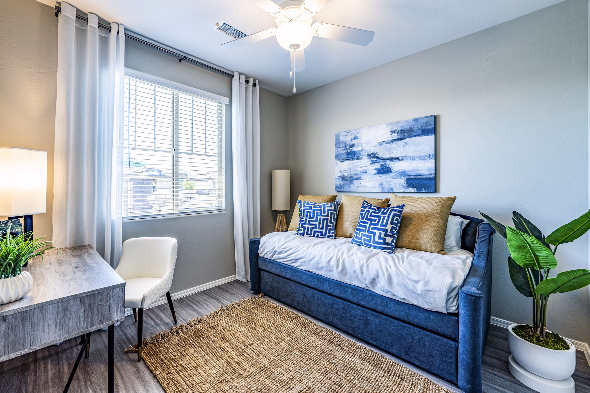 Contemporary bedroom with home office space at Vlux at Queen Creek Apartments