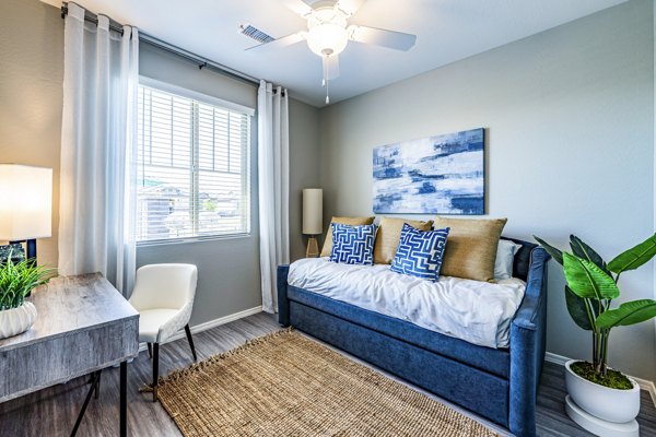 Contemporary bedroom with home office space at Vlux at Queen Creek Apartments