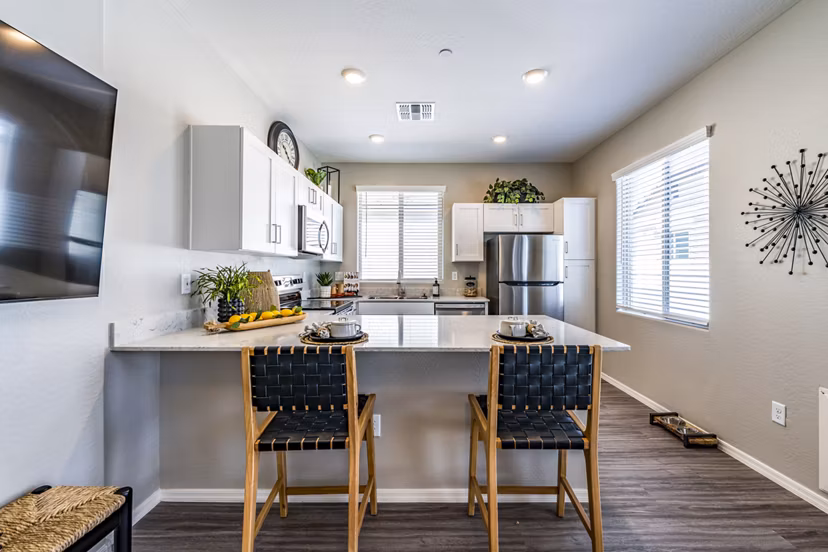 Modern dining room and kitchen with sleek finishes at Vlux at Queen Creek Apartments