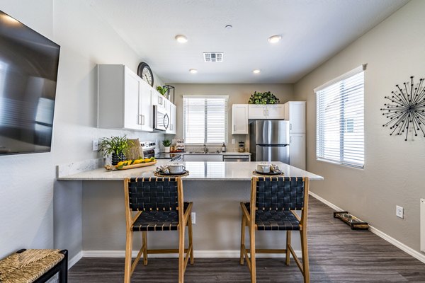 Modern dining room and kitchen with sleek finishes at Vlux at Queen Creek Apartments