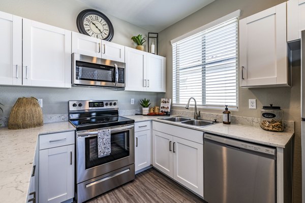 Modern kitchen with sleek countertops and stainless steel appliances at Vlux at Queen Creek Apartments