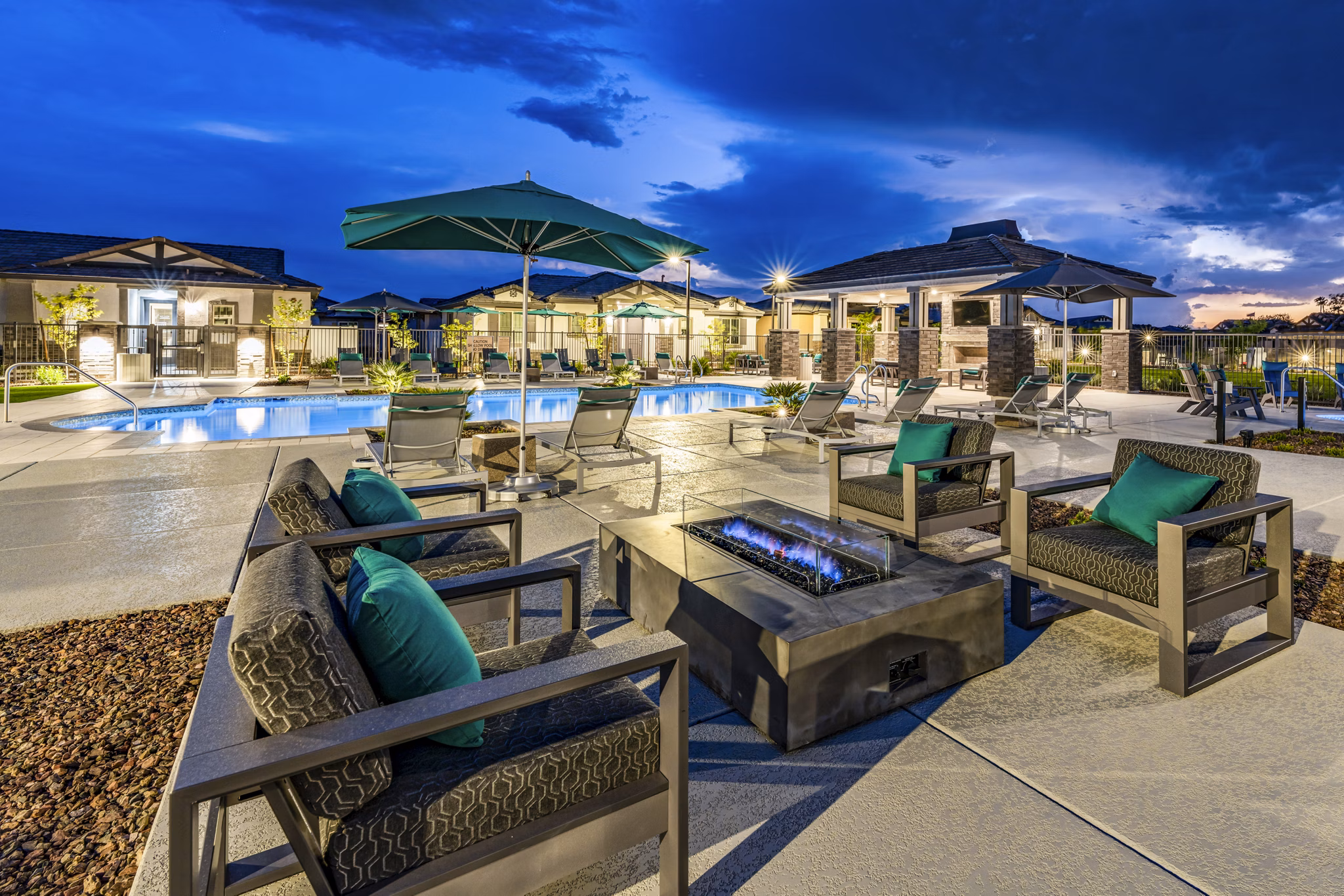 Cozy fire pit and patio area at Vlux at Queen Creek Apartments, perfect for relaxing outdoor gatherings