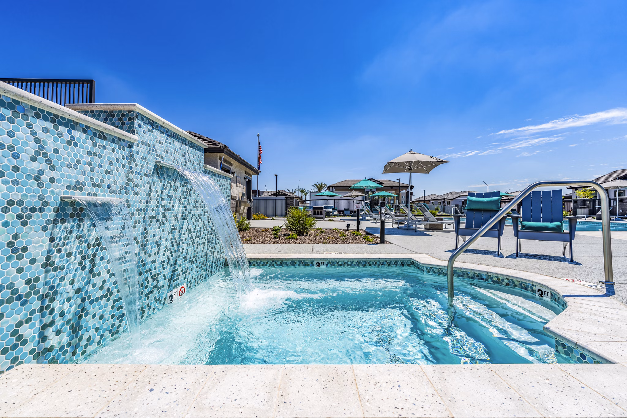 Resort-style pool with shaded lounge seating at Vlux at Queen Creek Apartments