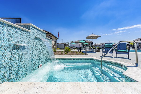 Resort-style pool with shaded lounge seating at Vlux at Queen Creek Apartments