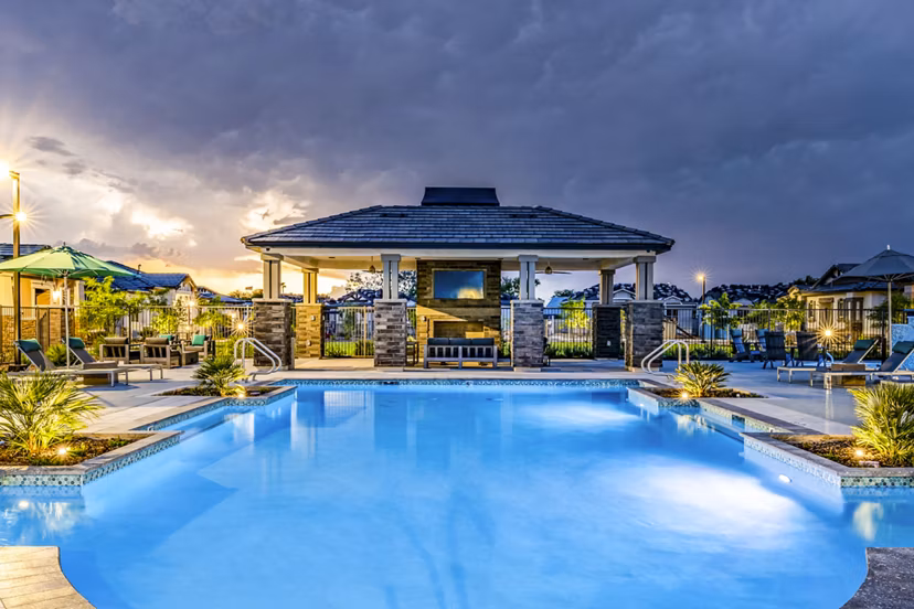 Resort-style pool with lounge chairs at Vlux at Queen Creek Apartments, offering a luxury living experience