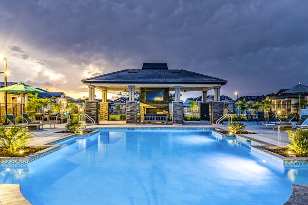 Resort-style pool with lounge chairs at Vlux at Queen Creek Apartments, offering a luxury living experience