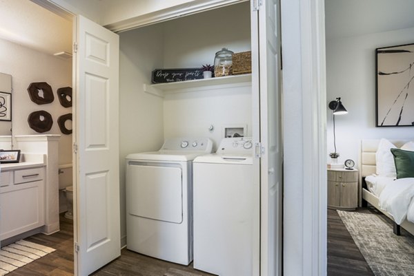 Laundry room with modern washers and dryers at The Aubry Apartments, a luxury property by Greystar