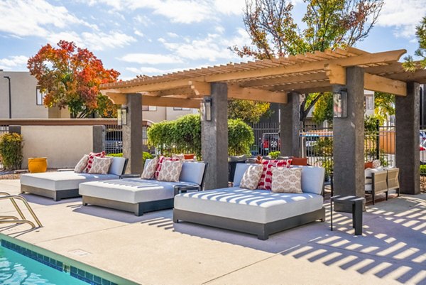 Poolside relaxation at The Aubry Apartments: Spacious patio with seating and umbrellas, enhancing luxury living experience