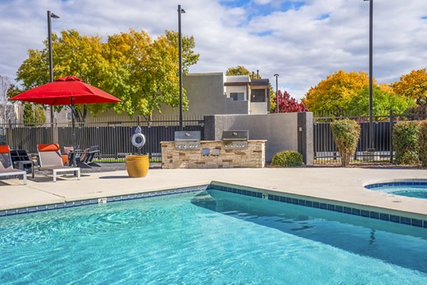 Grill area with poolside seating at The Aubry Apartments, by Greystar Ideal for social gatherings and relaxation