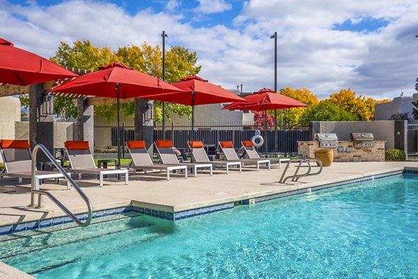 Outdoor grill area with poolside patio at The Aubry Apartments, a luxury living space