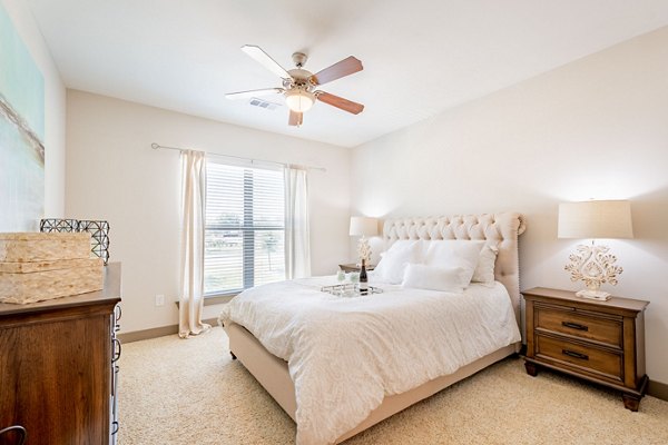 Cozy bedroom with modern decor at Larkspur at Twin Creeks Apartments, luxury living by Greystar