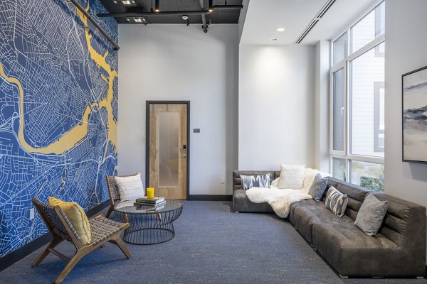 Modern clubhouse with cozy seating and large TV at 1550 on the Charles Apartments