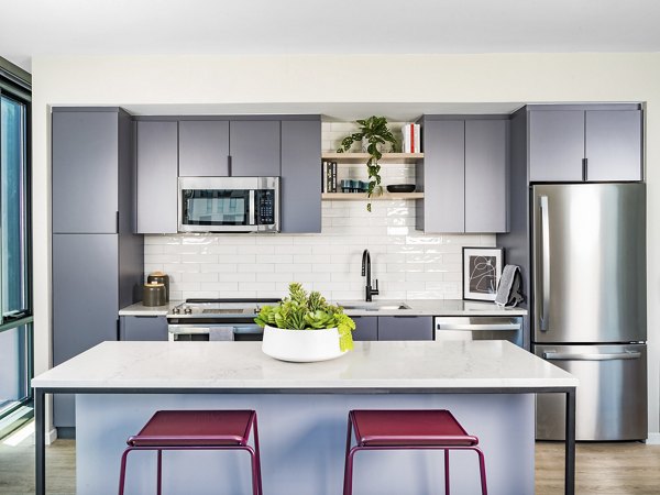 Modern kitchen with stainless steel appliances and marble countertops at Market House Apartments, perfect for gourmet cooking