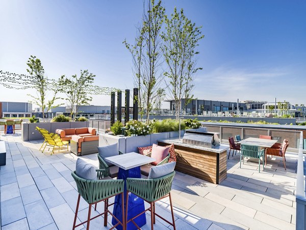 Rooftop deck with modern seating and city skyline views at Market House Apartments