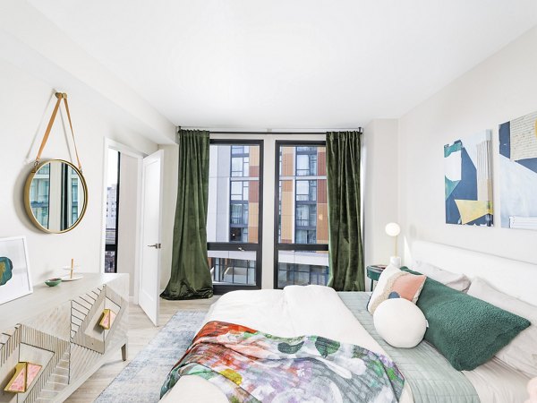Elegant bedroom with stylish decor at Rigby Apartments, featuring plush bedding and modern lighting