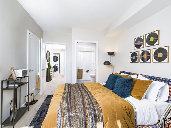 Cozy bedroom with natural light at Rigby Apartments featuring modern design and luxe finishes
