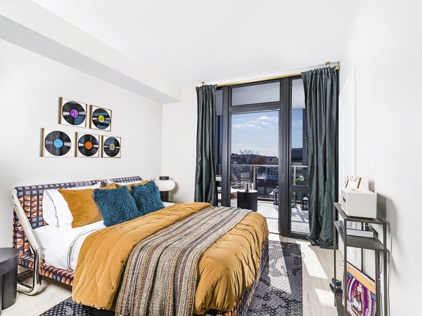 Bedroom featuring modern design and large window at Rigby Apartments