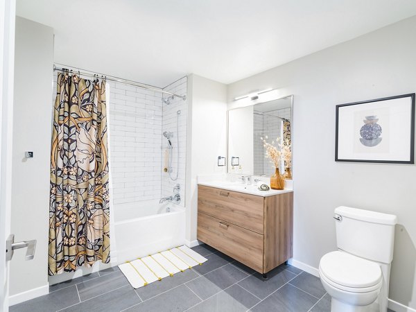 Elegant bathroom with ceramic tiles and modern fixtures in Rigby Apartments' luxury units