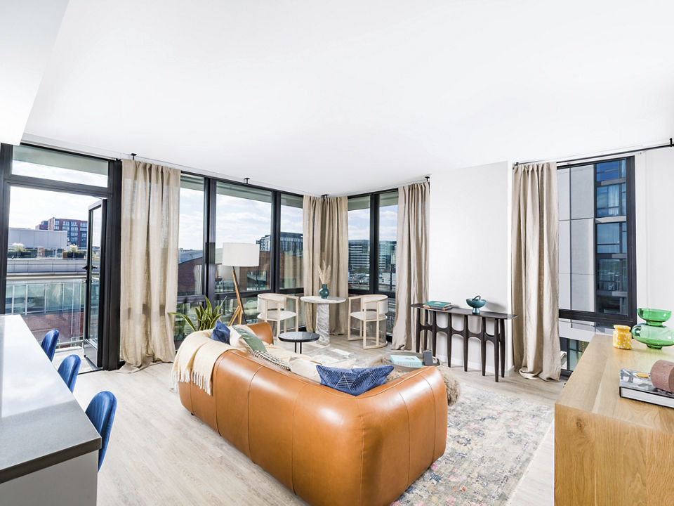 Spacious living room with modern decor and natural light at Rigby Apartments