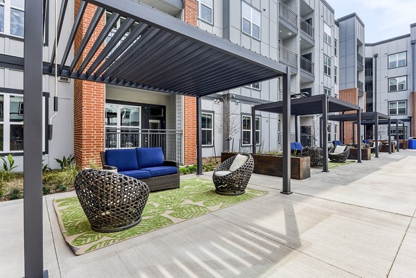 Poolside patio with modern seating at Art House SATX Apartments, offering luxury outdoor relaxation