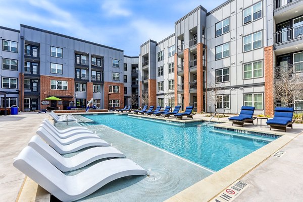 Resort-style pool at Art House SATX Apartments with modern loungers