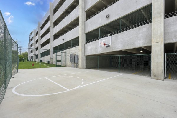 Outdoor sport court at Art House SATX featuring basketball and tennis facilities for active living