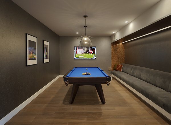 Game room with pool table, TV, and framed art in luxury apartments