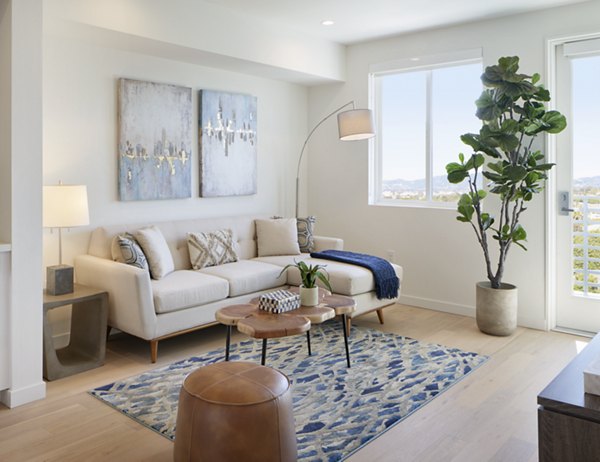 Spacious living room with modern decor and large windows in Eastway Apartments
