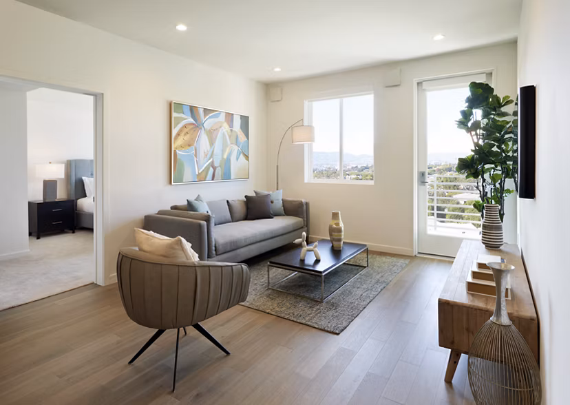 Spacious living room featuring modern decor and ample natural light at Eastway Apartments