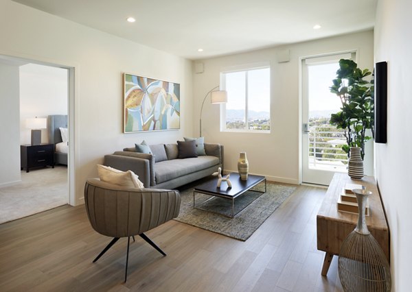 Spacious living room featuring modern decor and ample natural light at Eastway Apartments