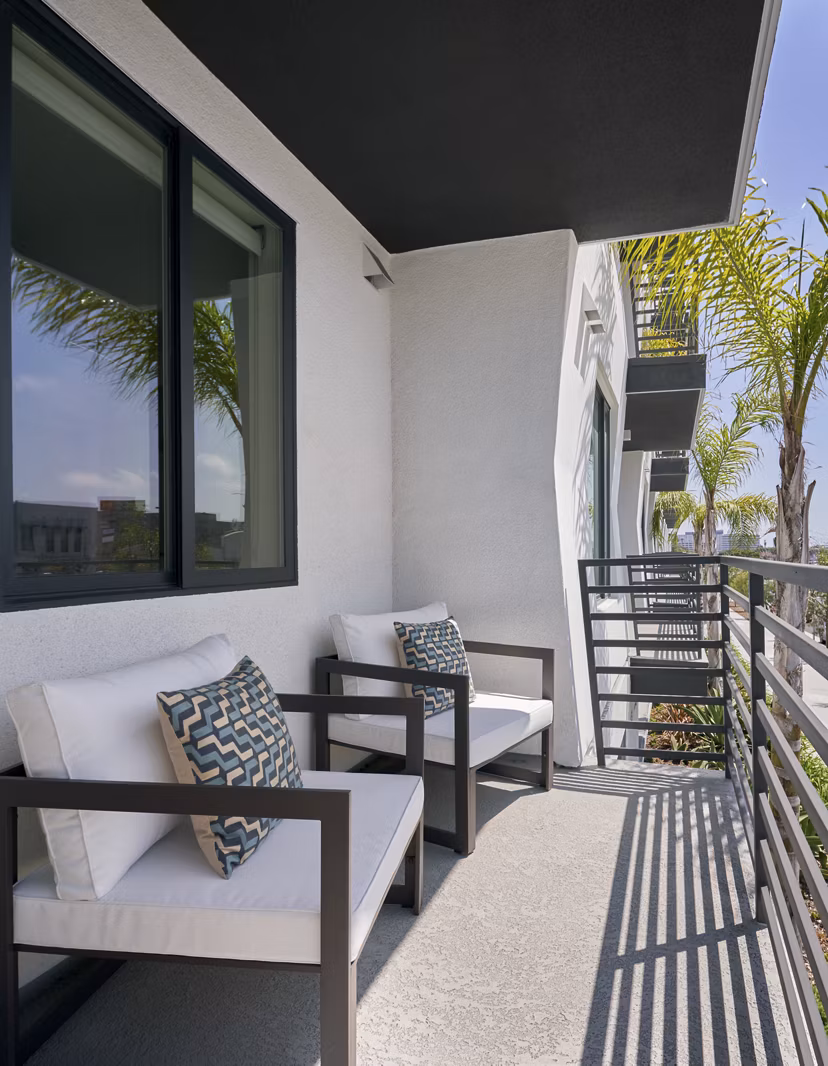 Expansive patio with outdoor seating at Eastway Apartments, perfect for relaxation and gatherings in a serene setting