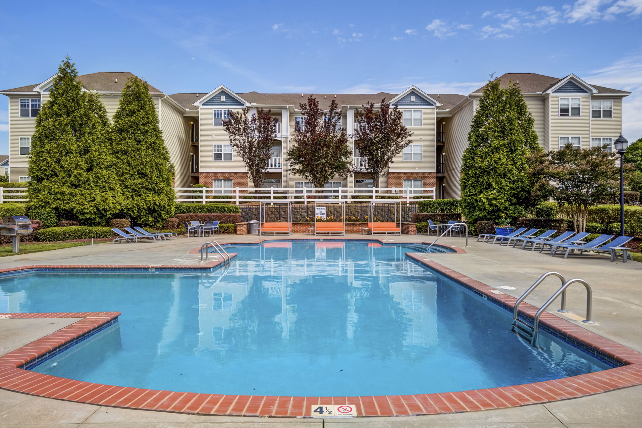 Resort-style swimming pool with sun loungers at Avant at Steele Creek luxury apartments